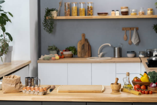 istock Kitchen table with wooden board, kitchenware, vegetables and ingredients for dough 1363959684