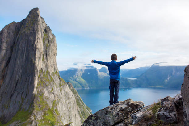 famille heureuse, debout sur un rocher et regardant la montagne segla sur l’île de senja, au nord de la norvège. incroyable beau paysage et nature splendide - mountain climbing rock climbing motivation awe photos et images de collection