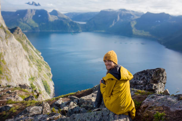 famille heureuse, debout sur un rocher et regardant la montagne segla sur l’île de senja, au nord de la norvège. incroyable beau paysage et nature splendide - mountain climbing rock climbing motivation awe photos et images de collection