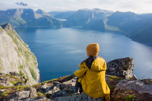 szczęśliwa rodzina, stojąca na skale i patrząca na górę segla na wyspie senja w północnej norwegii. niesamowity piękny krajobraz i wspaniała przyroda - mountain climbing rock climbing motivation awe zdjęcia i obrazy z banku zdjęć