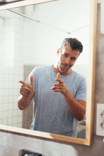 istock White Man Checking Himself Out in a Bathroom Mirror 1363961644