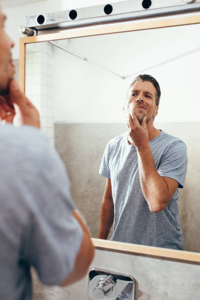 istock White Man Checking Himself Out in a Bathroom Mirror 1363961645