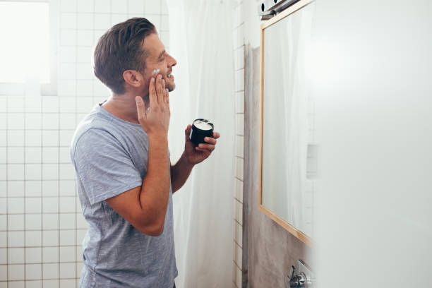 istock Handsome White Man Applying Face Cream 1363961686