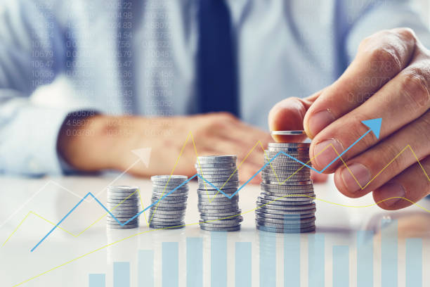istock A man stacks a stack of coins, with a savings chart in the foreground 1363963025