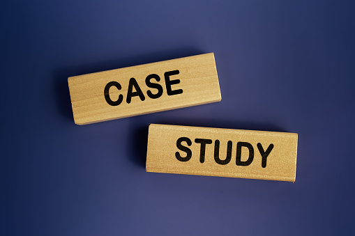 The words 'CASE STUDY' is written on a wooden blocks on a dark blue background. Concept text