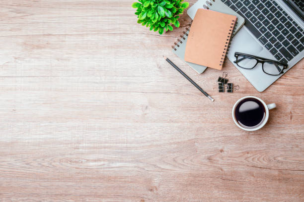 istock Work from home. desk office with laptop, blank notepad, coffee cup and pen on wood table. Flat lay top view copy spce. 1363964622