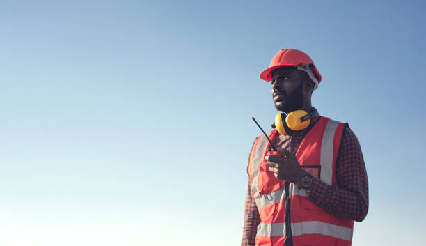 nahaufnahme professionelle afroamerikanische männliche ingenieure nutzen funkkommunikation, um effizient in industriefabriken zu kommunizieren. - harbor commercial dock engineer service stock-fotos und bilder