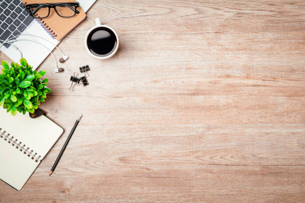 istock Work from home. desk office with laptop, blank notepad, coffee cup and pen on wood table. Flat lay top view copy spce. 1363964643