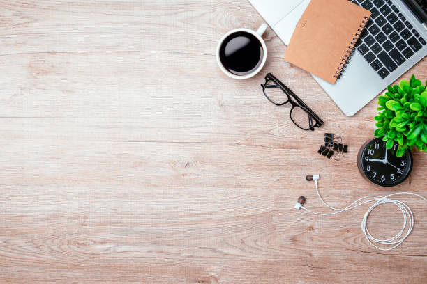 istock Work from home. desk office with laptop, blank notepad, coffee cup and pen on wood table. Flat lay top view copy spce. 1363964650