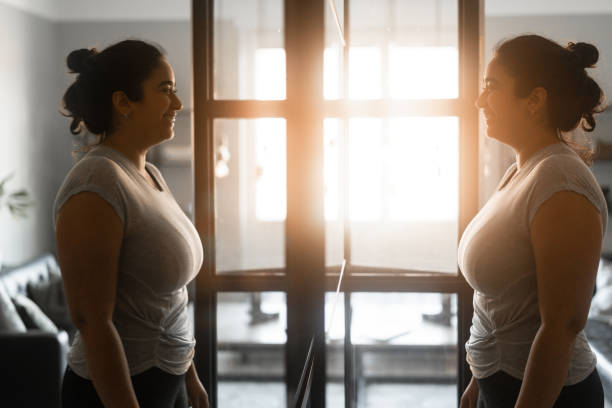 istock Woman smiling at herself in the mirror 1363971685
