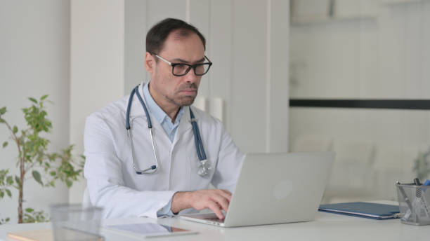 istock Middle Aged Doctor working on Laptop in Clinic 1363974761