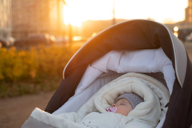 istock Little baby boy in stroller outdoors. Yellow leaves around him. 1363977516