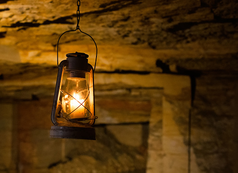 Old vintage candle lamp lantern ganging in Odessa catacombs cave. A photo with free empty copy space for text