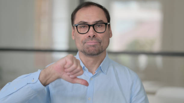 istock Middle Aged Man showing Thumbs Down Gesture 1363977839