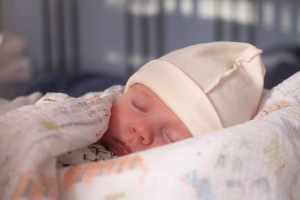 istock baby sleeping on white sheets in bed with a blanket. 1363979023
