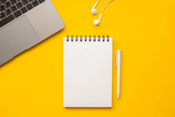 istock On a yellow background, a laptop, headphones, notepad and pen. 1363981251