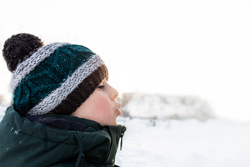 A child on a winter walk. Frosty breath.