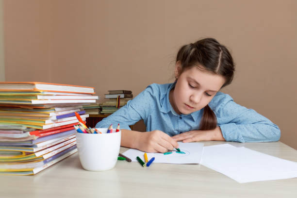 istock girl child draws while sitting at the table. Selective focus. 1363984018