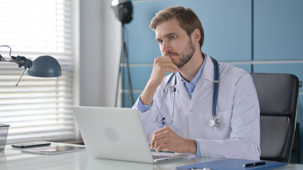 istock Doctor Thinking while Working on Laptop in Clinic 1363984931
