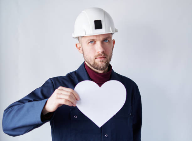 istock Valentine's Day: male worker in helmet with paper heart 1363984955