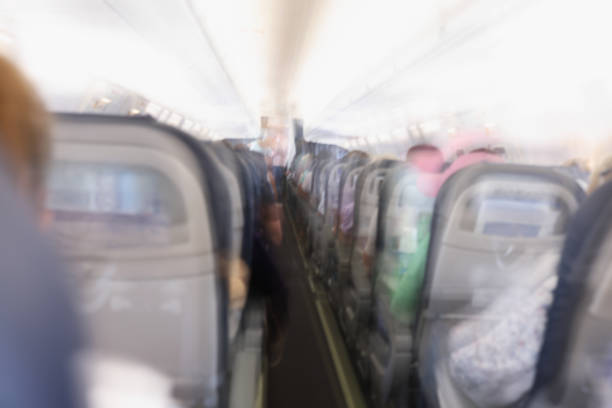 Comfortable passenger cabin of the aircraft, rear view, flashing. Fear of flight, aerophobia. Plane crash, blurred consciousness, blurry
