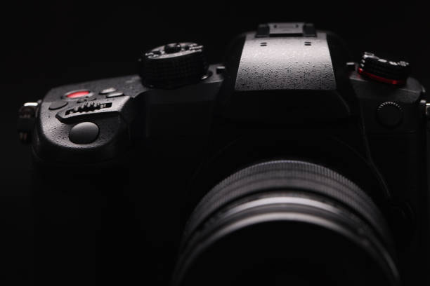 istock Digital stylish black camera on a black background, close-up 1363985047