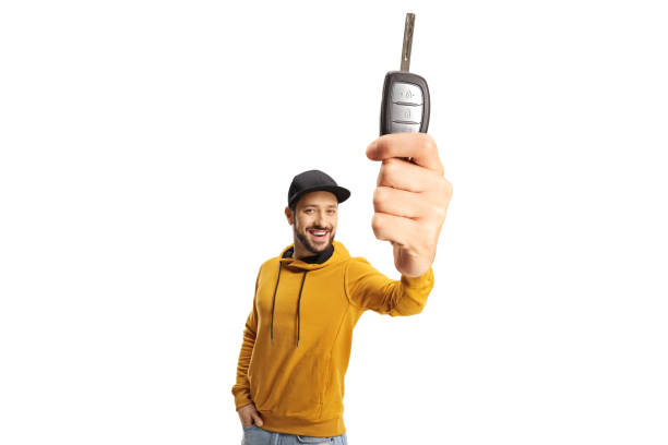 istock Cheerful guy with a yellow sweatshirt holding a car key 1363987215
