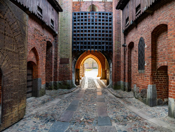 Main entrance gates of Malbork Castle (Marienburg, Zamek w Malborku). Malbork - courtyard of The Castle of the Teutonic Order in a sunny autumn day. Blue sky on the background. marienburg stock pictures, royalty-free photos & images