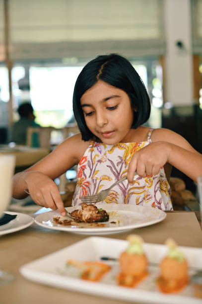 istock Girl enjoying her meal in a restaurant 1363987496