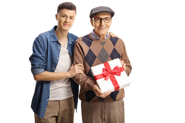 istock Young man standing next to an elderly man holding a present 1363987709