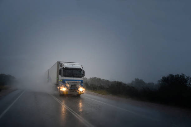 Road trains driving in the rain on the highway Bad weather on the highway. Long trucks - road trains are driving in a dangerous situation with water on the windshield truck rain stock pictures, royalty-free photos & images