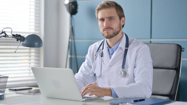 istock Doctor Shaking Head as Yes Sign while using Laptop 1363988450