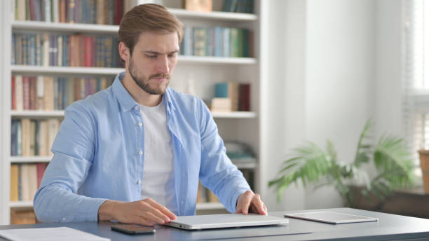 istock Man Closing Laptop and Leaving Office 1363988636