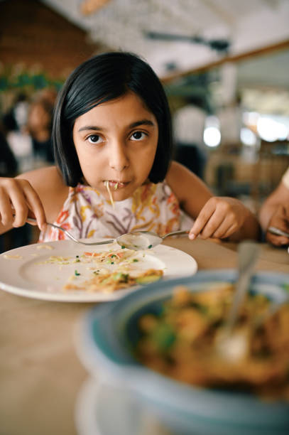 istock Girl eating in a restaurant 1363988764