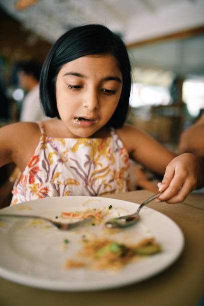 istock Girl eating in a restaurant 1363990175