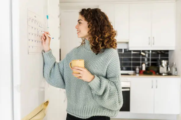 Photo of woman with hot cup at home, calendar