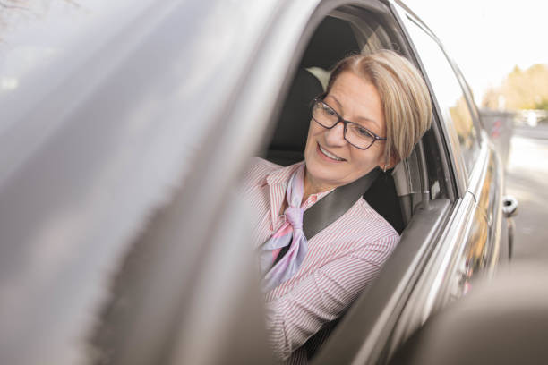 istock Beautiful senior woman using smartphone in the car 1363990531