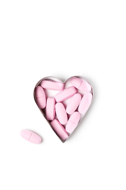 istock Pink organic vitamin tablets in heart-shaped form on white background 1363991426