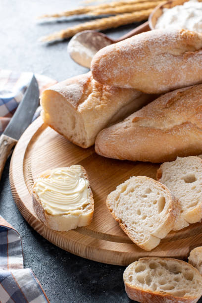 istock Fresh French Baguette Bread with butter on dark background 1363991865