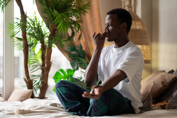 istock Young african man practicing yoga lesson, doing Alternate Nostril Breathing exercise 1363991912
