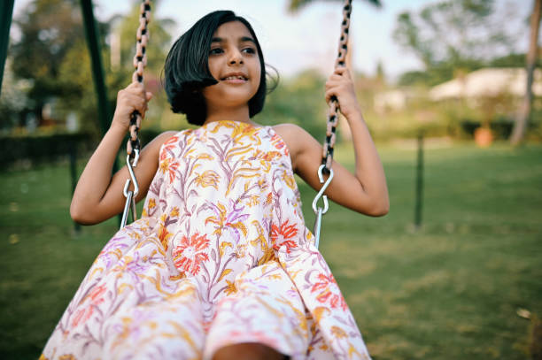 istock Girl playing on the swing 1363994442