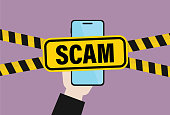 istock Hand holds a mobile phone with a scam sign 1363994757