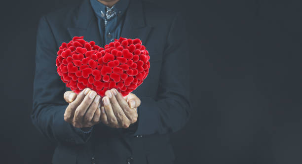 istock Businessman holding a red heart cherishly. 1363996039