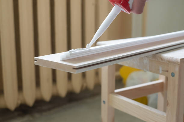 istock Process of installing ceiling skirting board. Place glue on it. 1363996476