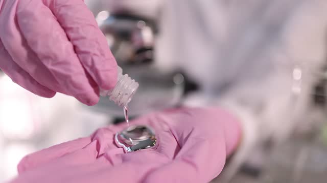 Scientist pours liquid mercury onto gloved hand