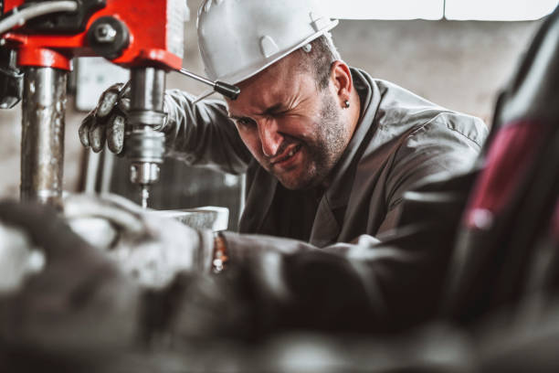istock Worker Closing One Eye In Factory To Be More Accurate While Drilling Metal Piece 1364005384