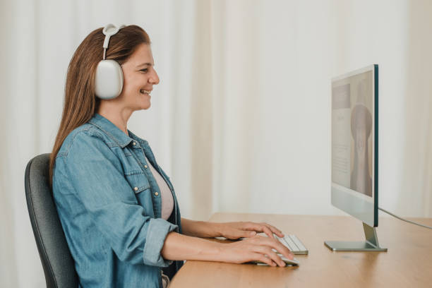 istock Woman in headphones using computer at home 1364006057