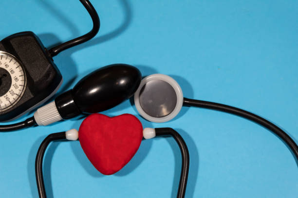 istock On a blue background, equipment for measuring pressure and a red heart. 1364009317