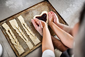Cute Baking Couple Wrapping Hands Around Heart Shaped Pastry