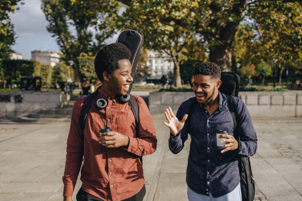 istock Two young Afro-Americans walking though a public park smiling 1364014650